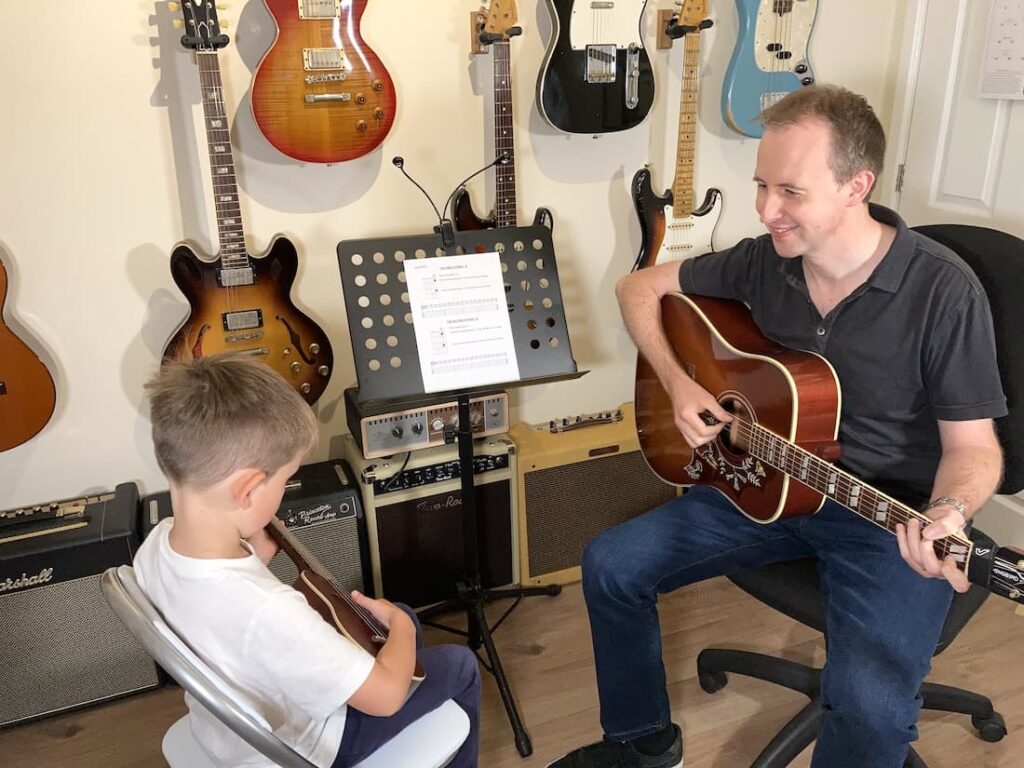 Photo of guitar lesson with boy